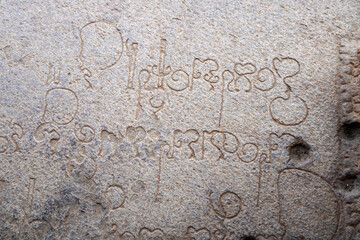 Inscriptions on the ancient temple stone walls. Ancient stone carving. Old stone wall texture. Tamil inscriptions in historical temple walls.
