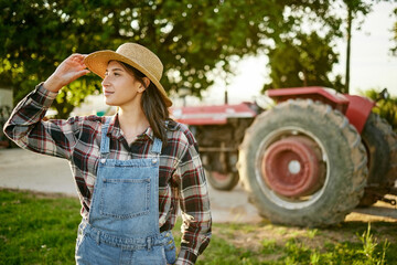 Farm, tractor and a woman in a hat in nature or field farming food, fruits and vegetables....