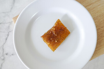 Fried pork skin on a white plate. Pig food culinary cuisine.