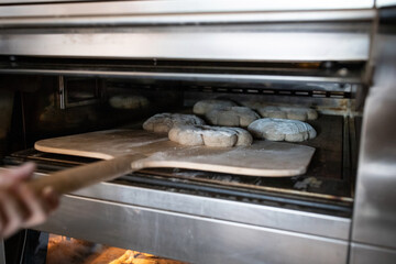 The process of making traditional French bread in an artisan bakery. Bordeaux Corona baking. Front view.