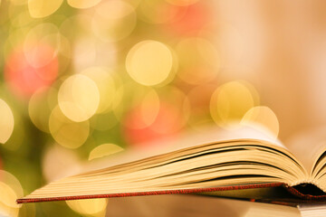 Winter books. Books on Christmas and winter themes.Stack of books on the table on shining twinkling...