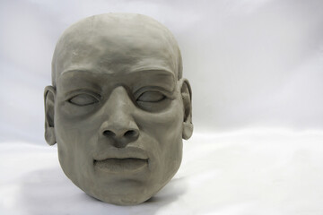 Clay face sculpture. Portrait of African man on white blurred background. Art work, contemporary...