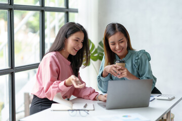 Two young Asian business women discuss work and jointly plan sales and marketing strategy to the company in making new product.