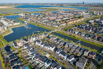 Obraz na płótnie Canvas Modern green neighbourhood in Almere, The Netherlands, surrounded by water and nature, city built on reclaimed land (Flevoland polder). Aerial view.