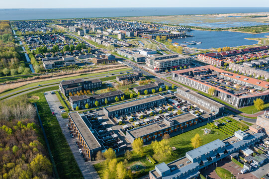 Modern green neighbourhood in Almere, The Netherlands, surrounded by water and nature, city built on reclaimed land (Flevoland polder). Aerial view.