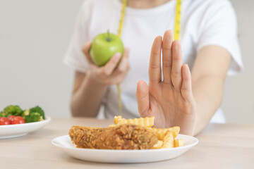 Diet, Dieting asian young woman hand in push out, deny fried chicken, french fried and choose green apple, vegetables salad, eat food for good healthy, health when hungry. Female weight loss people.