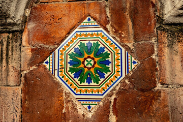 Colorful tile on the brick house wall in the historical district of Mexico