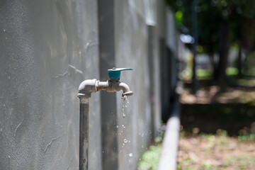 Old faucet outside the house dripping