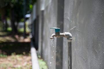 Old faucet outside the house dripping
