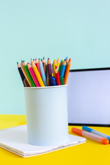 Fototapeta premium Tablet and notebook for online study on yellow and blue