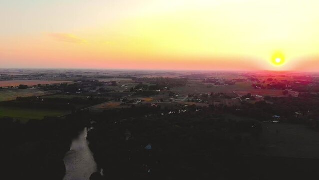 
Top angle aerial view Drone shot of homes and farms in Ririe, Idaho with green trees and woods in a beautiful  colorful orange sunset 4K UHD 3840