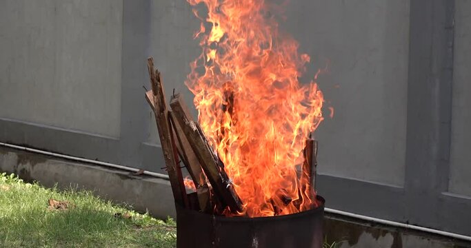 Burning orange flame in barrel outdoor. Made barrel, burning inside. Close up