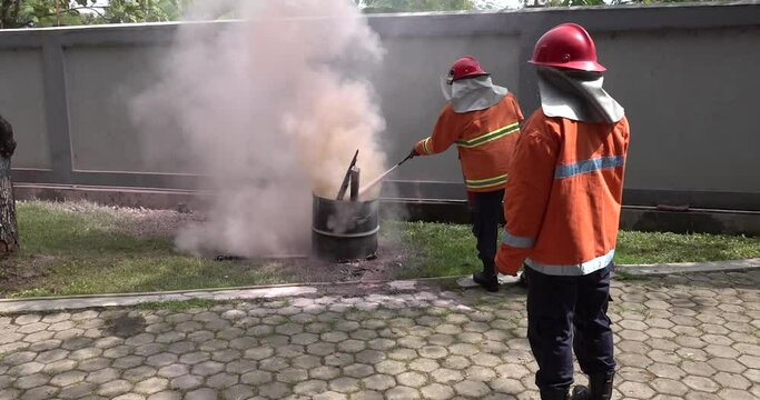 fighting fire during training. Some firefighters practises how to use a fire-extinguisher by using apar