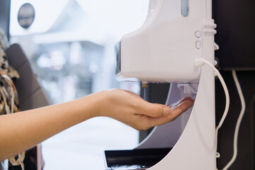 Hygiene concept, hands being sprayed with alcohol from automatic machines, killing germs, viruses and bacteria.