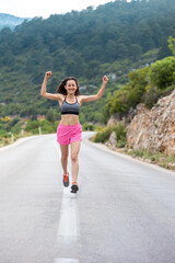 The runner finished and put his hands up, a woman on an evening jog