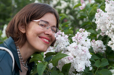 Fototapeta premium Close up portrait of beautiful smiling woman near white lilac