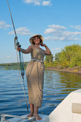 Girl on the bow of a sailing ship against the blue sky