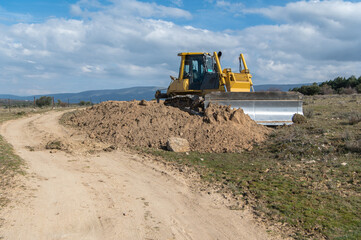 Obraz premium Excavator moving dirt and sand at a construction site