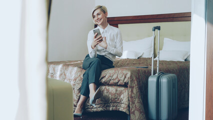 Happy cheerful businesswoman talking with family via online video chat using smrtphone camera...