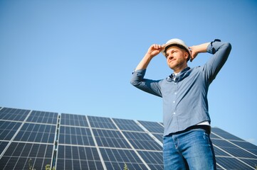 Young architect standing by solar panels