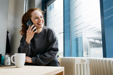 young redhead woman talking on cell phone during her break