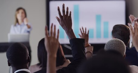 Audience of business people asking the speaker a question while lifting their hands during conference. Manager speaking about data at corporate tradeshow. Woman mentor train team at company workshop