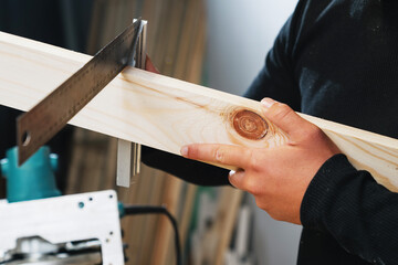 Close-up of the carpenter's hands, which measures the evenness of the board with a ruler before starting work on the manufacture of furniture