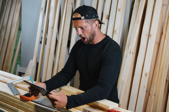 An Emotional Portrait Of A Carpenter Who Saw His First Order On A Tablet. Starting Your Own Business