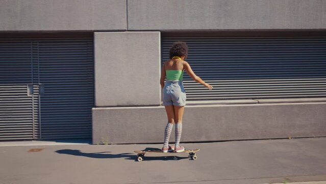 Beautiful young woman cruising around the city with her longboard.  Female teenager practicing longboard dance discipline. Concept about sport and lifestyle