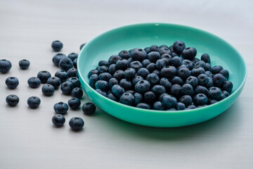 Fototapeta na wymiar Fresh Blueberries blueberry BowlTable Freshly picked turquoise bowl. Juicy and fresh blueberries Bilberry white wood food Background. antioxidant. Concept healthy eating nutrition fruit top view