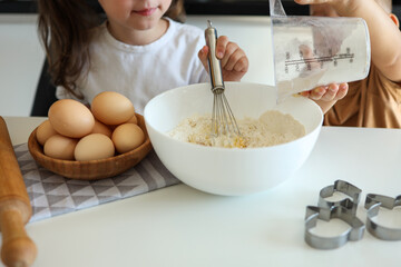 Little girl breaking an egg close-up, cooking master class