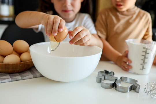 Little girl breaking an egg close-up, cooking master class