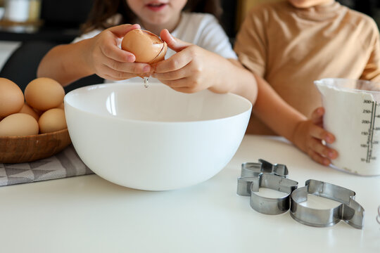 Little girl breaking an egg close-up, cooking master class