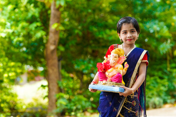Cute indian little girl celebrating lord ganesha festival. - Powered by Adobe