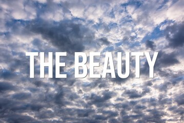 THE BEAUTY - word on the background of the sky with clouds.