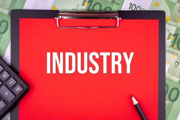 INDUSTRY - word on the background of money, a notepad and a pencil with a calculator. Business...