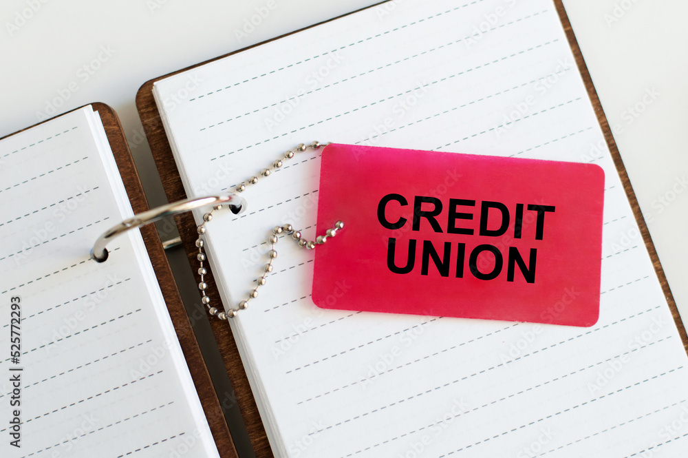 Poster credit union text on a red tag on the chain, which lies on the notepad open on the rings