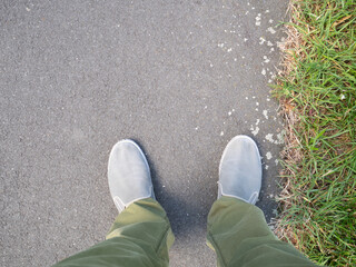 Feet on the asphalt road in the city.