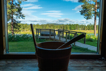 Sorsele,Sweden A water bucket and laddle in a sauna with a window over Swedish Lappland.