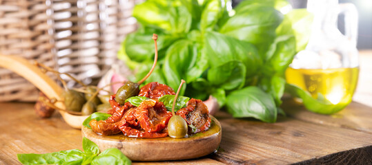 Dried tomatoes with herbs and olive oil. Traditional canned tomatoes in Italy with garlic, Provence herbs and basil. Ingredients for bruschetta and aperitif. Copy space