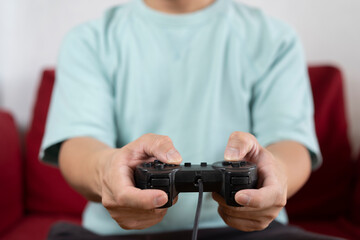 Young man using a video game controller, playing video games.