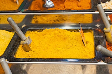 Curcuma powder on a container at the Boquería in Barcelona (Spain), selective approach to the aluminum pan.