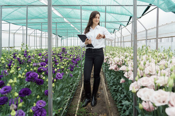 Fresh flowers delivery, women taking order on the tablet. Businesswoman using technologies in her flower business.