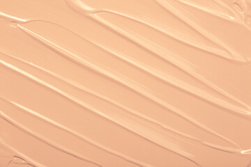 Foundation smeared as a swatch as a close-up background. Makeup cosmetics. Tone cream. Concealer texture.