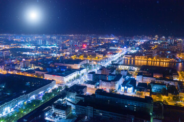 Fototapeta na wymiar Aerial view of the night modern city. Bright moon and lights of the night streets