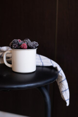 frosen berries in a mug black background