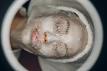 Paraffin Face Mask gauze bandage Therapy Young Woman Receiving Facial Skin Care Treatment....