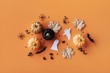 Halloween holiday background with party decorations of pumpkins, bats, ghosts, spiders on orange...