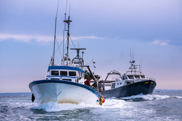 Barco de pescadores navegando de vuelta al puerto después de una jornada de trabajo en el mar, Costa Brava, Mediterraneo