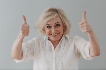 Elderly caucasian old aged woman portrait gray haired smiling portrait with thumbs up gesture
